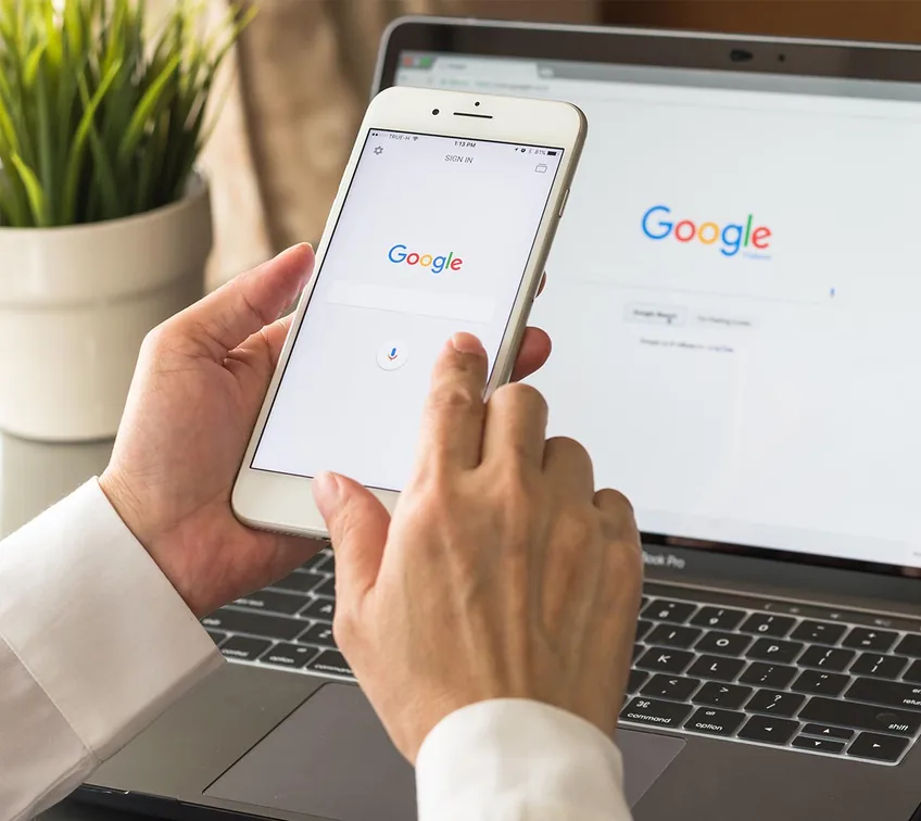 Recherche Google sur téléphone et ordinateur illustrant la visibilité web